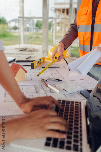 Construction contractor, checking and recording construction details using tape measure and not measuring water level, wearing yellow construction uniform, house construction contractor, concept