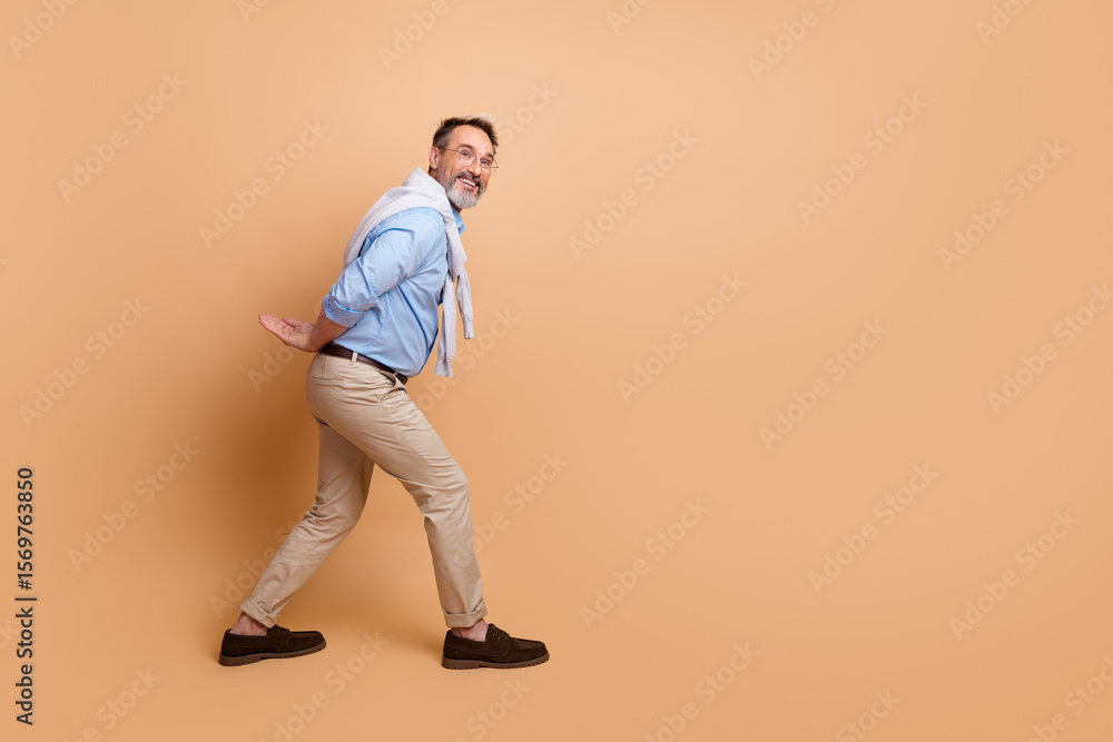 Elegant mature businessman posing against beige background wearing casual formalwear and showcasing a sophisticated confident demeanor Elegant mature businessman posing against beige background wearing casual formalwear and showcasing a sophisticated confident demeanor