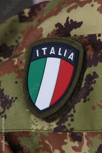 Shield symbol of the Italian flag on military uniform background, Italy