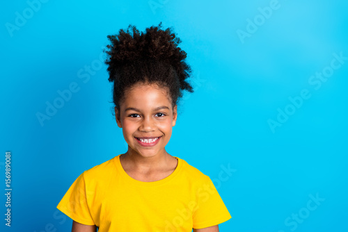 Photos Charming preteen girl with afro hair and yellow shirt posing in front of a vibra