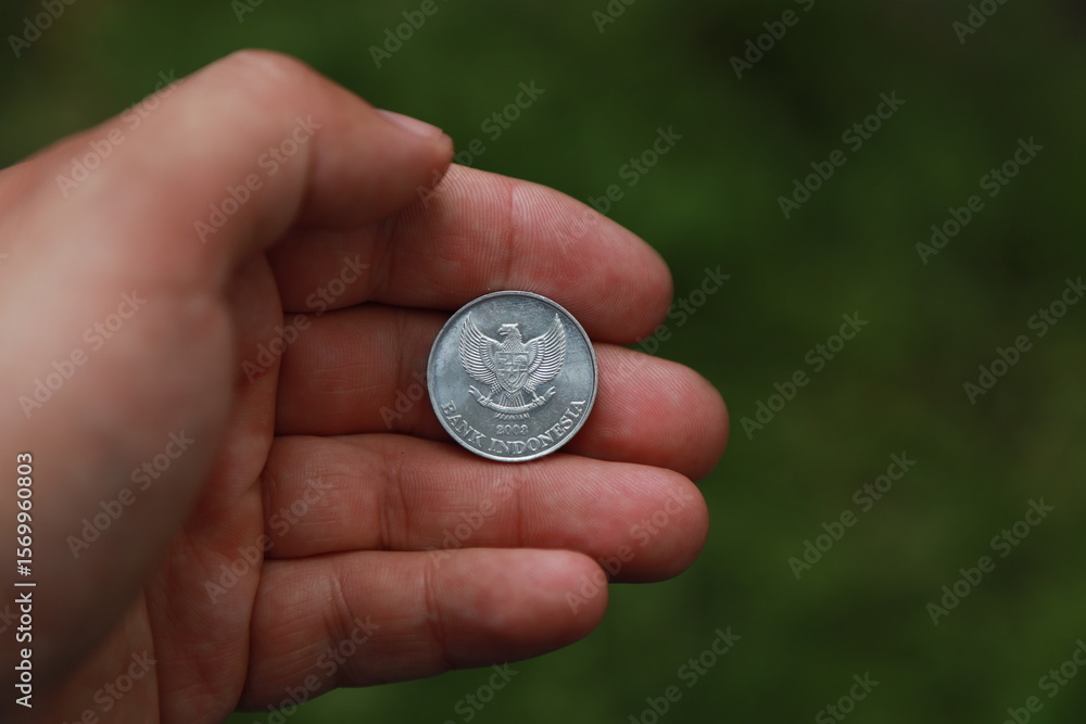 Indonesian change coin in hand Indonesian change coin in hand