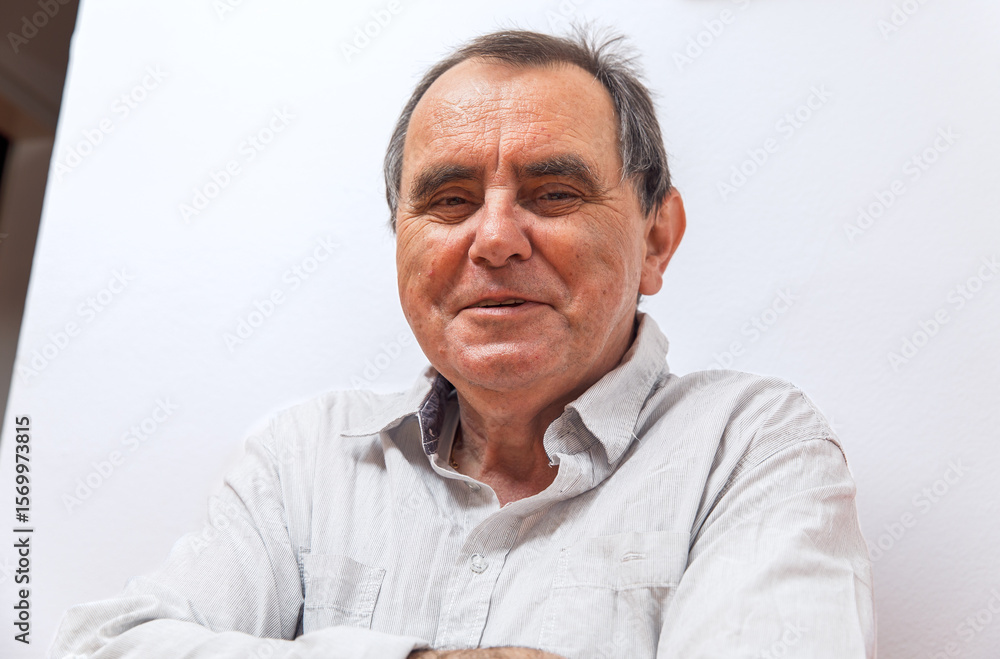 Obraz premium Elderly caucasian male smiling in light shirt against white background