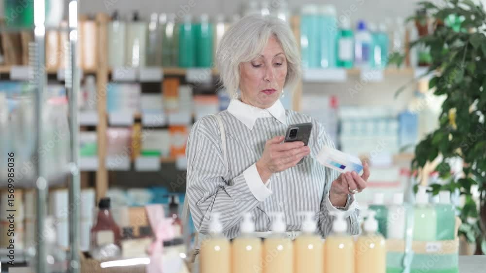 Elderly woman buyer scanning qr code for box of ointment in pharmacy Elderly woman buyer scanning qr code for box of ointment in pharmacy