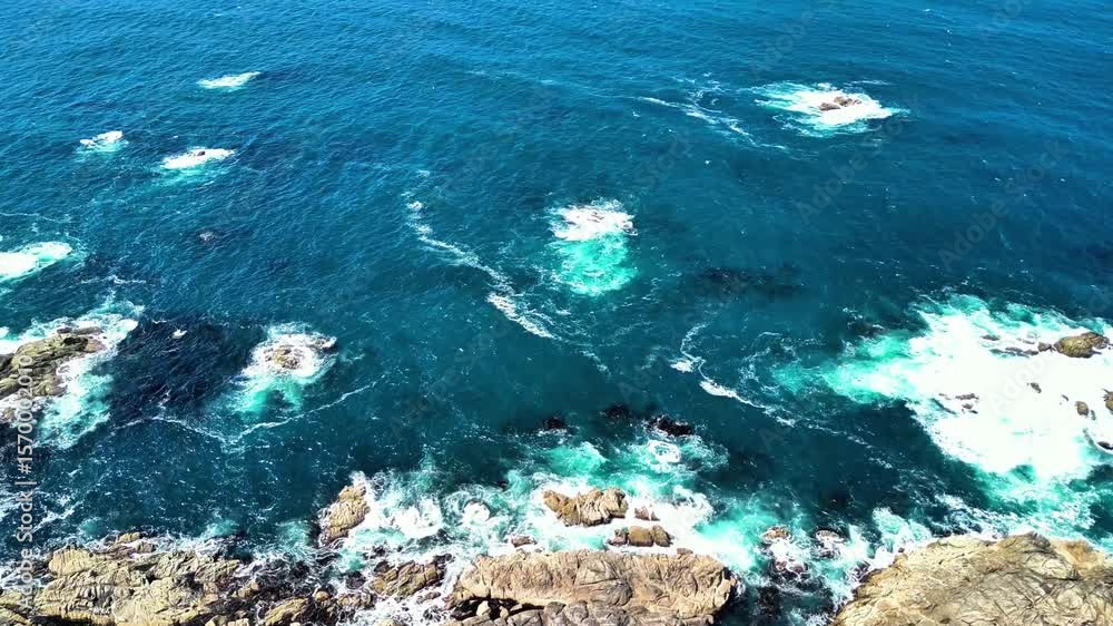 A breathtaking aerial view of turquoise waters and rugged shorelines with waves crashing gracefully A breathtaking aerial view of turquoise waters and rugged shorelines with waves crashing gracefully