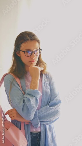 Thoughtful young woman with glasses deep in academic consideration. Great for research, strategy and analytical themes