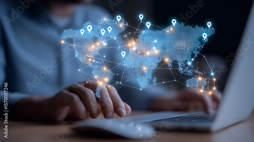 Global Connection: A person is working on a laptop with a holographic projection of the world map and location pins, illustrating the concept of global network, technology, and worldwide reach. 