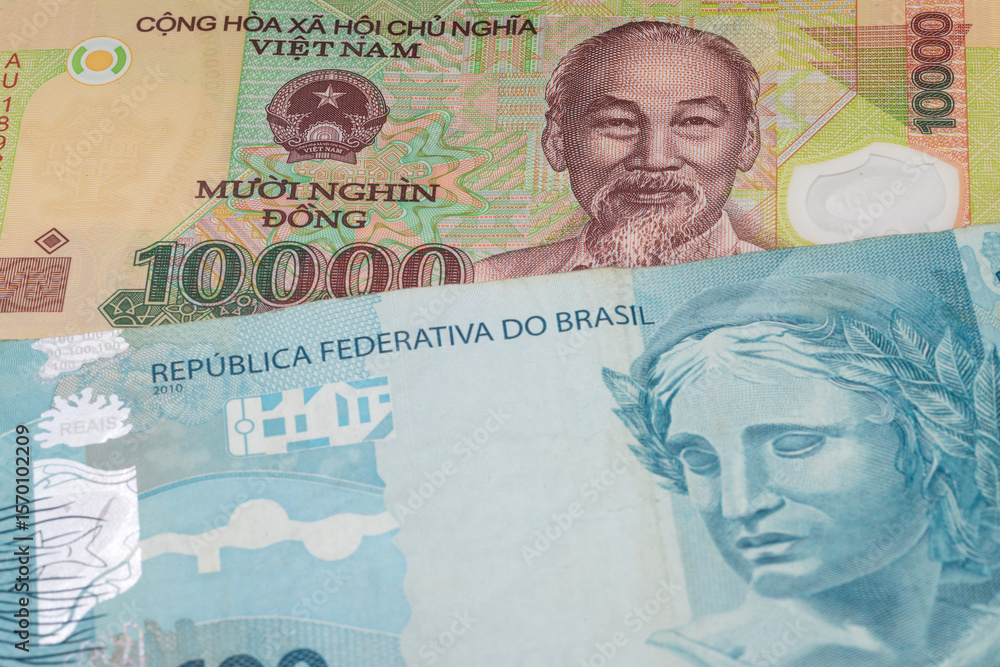 Fototapeta premium 10000 Vietnamese dong and 100 Brazilian real banknotes. International trade concept