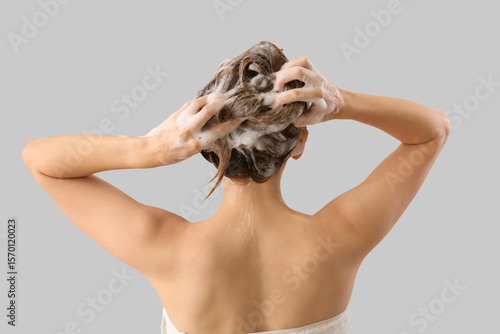 Young woman washing hair on...