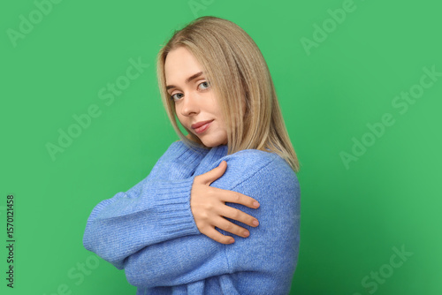 Young woman hugging herself...