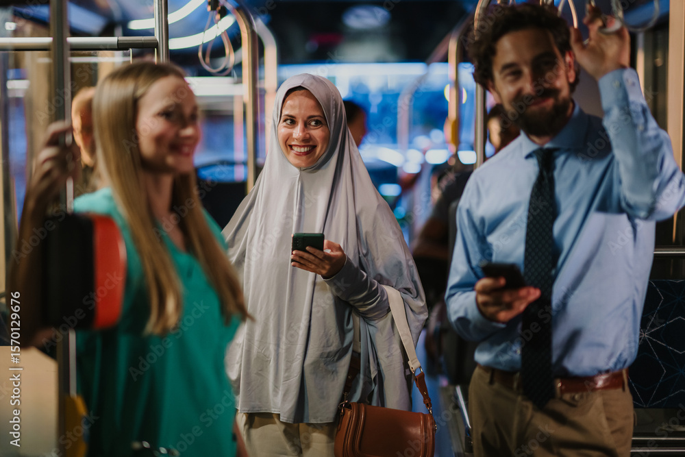 Multi ethnic commuters using smartphones on a bus or tram Multi ethnic commuters using smartphones on a bus or tram