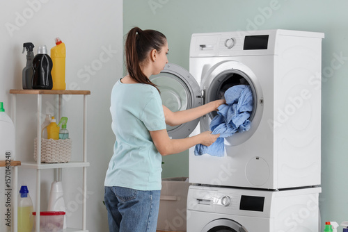 Young woman doing laundry i...