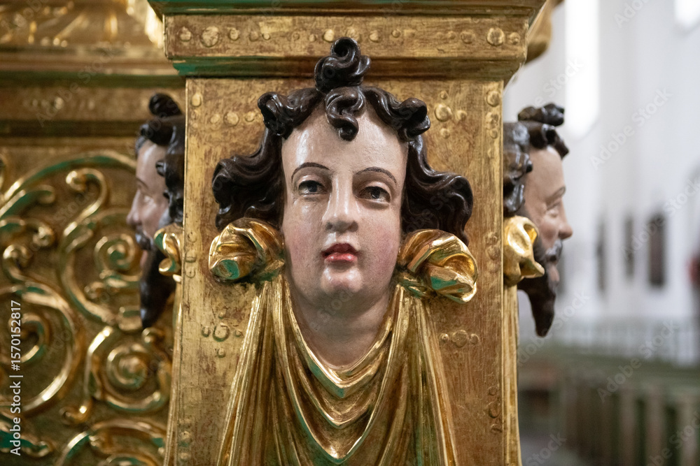 Obraz premium Close-Up of Ornate Golden Carved Head on Wooden Altar in Lidzbark Warminski, Poland