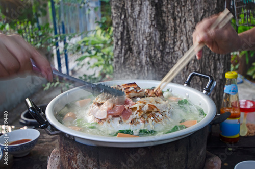 Outdoor Thai barbecue hotpot in action eating