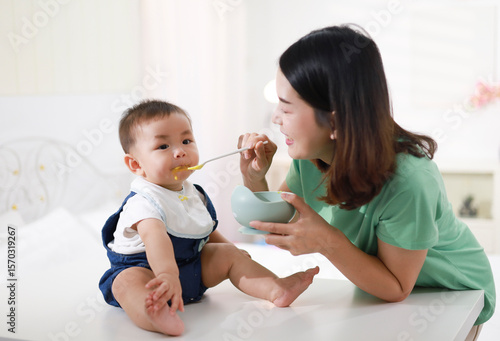 Obraz na płótnie The mother who is feeding her little boy on the table wants to be happy