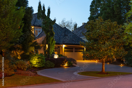 Two story stucco luxury house with nice Spring blossom landscape at night in Vancouver, Canada, North America. May 2025.