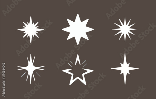 A collection of six unique white starburst and sparkle graphic elements with sharp points and glowing effects displayed against a dark brown background