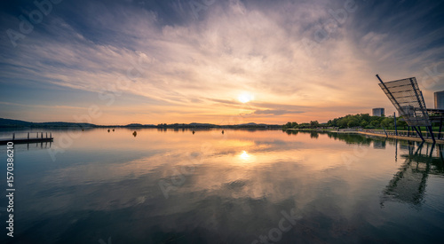 Fotografie Tranquil Sunset Reflections Over a Calm Lake in Nature's Embrace
