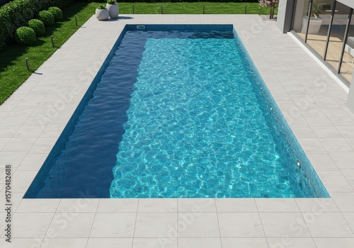 Aerial view of a rectangular swimming pool with turquoise water surrounded by white tiles and greenery