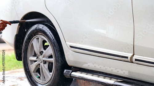 Wallpaper Mural Close-up of hands washing car tire with high-pressure water at car wash Torontodigital.ca