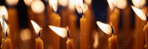 Foto Header of multiple burning candles with soft flames in church setting, wax melti