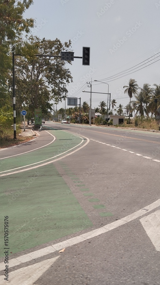 Obraz premium Empty Road with Marked Bike Path and Clear Sky for Sustainable Travel