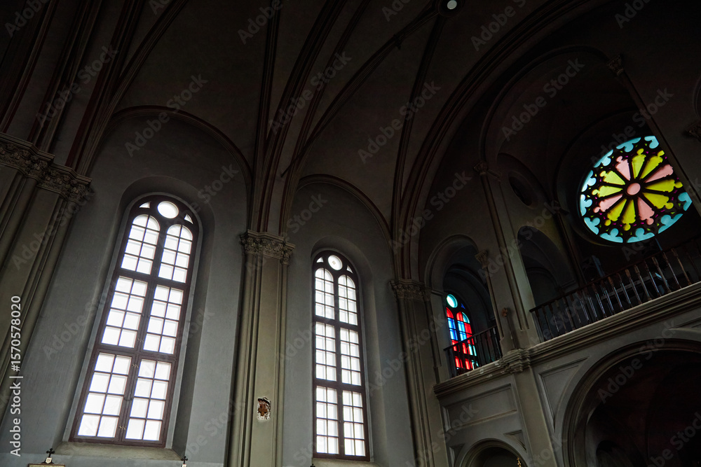 Interior of church showing tall arched windows and colorful stained glass, capturing architectural details and religious setting with no people visible in frame Interior of church showing tall arched windows and colorful stained glass, capturing architectural details and religious setting with no people visible in frame