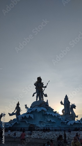 Majestic Statue Silhouetted Against a Golden Beach Sunset