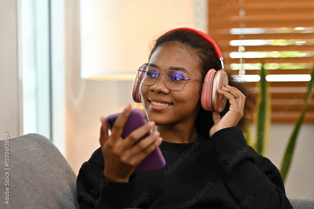 A Young African Woman Enjoying Music with Headphones, Casual indoor lifestyle moment with technology and relaxation A Young African Woman Enjoying Music with Headphones, Casual indoor lifestyle moment with technology and relaxation