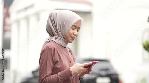 Young Indonesian Muslim Woman Using Smartphone in Kota Lama or Old Town area, Semarang, Indonesia