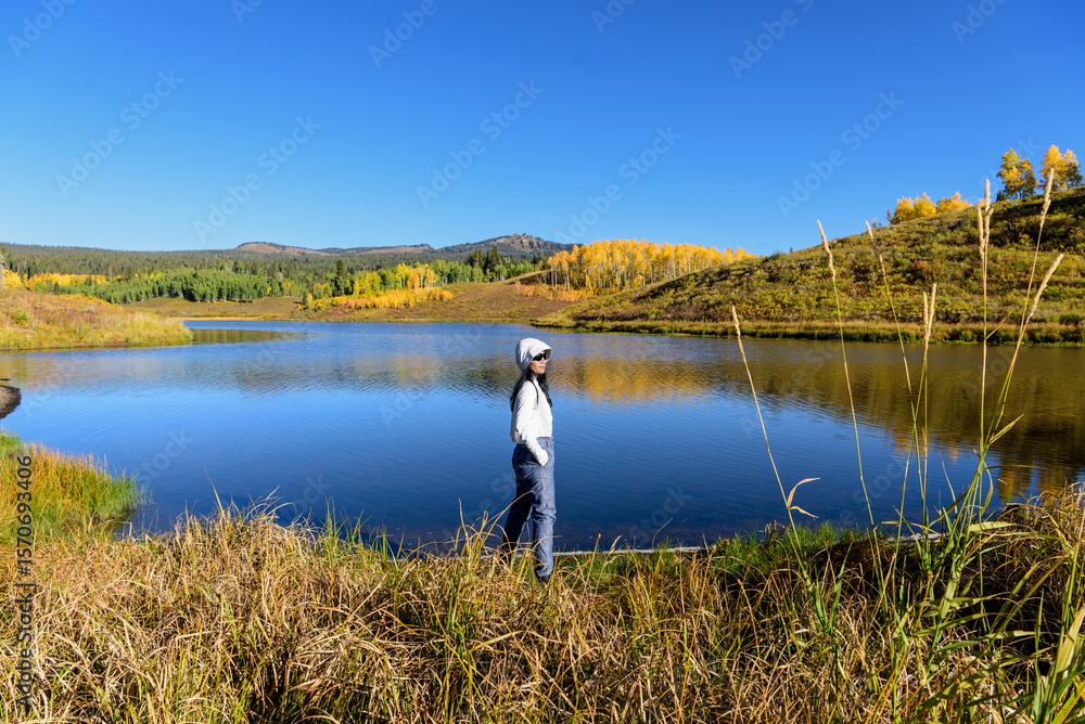 Fototapeta premium A hiker enjoys the mirrored fall colors in Steamboat, Colorado.