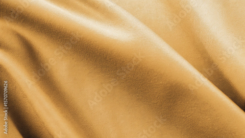 Golden, soft silk satin fabric with a smooth, shiny texture creates a luxurious and elegant golden textile background pattern