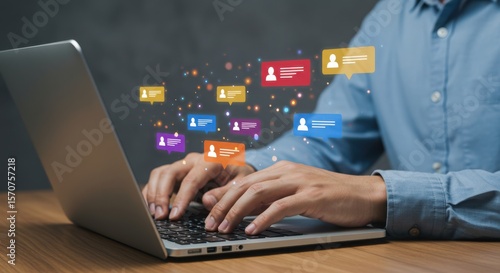 Photo of a man types on a laptop with colorful chat bubbles floating above