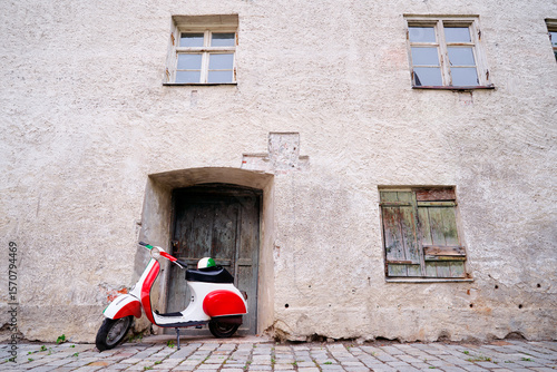 Motorbike outdoor. Red white retro style scooter on old town street.