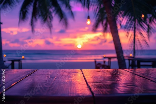 Wooden table on a beach at sunset with a vibrant color palette.