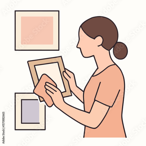 Woman Cleaning Picture Frame At Home