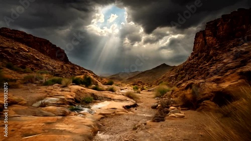 Sunbeams illuminating a dry wash through rocky terrain