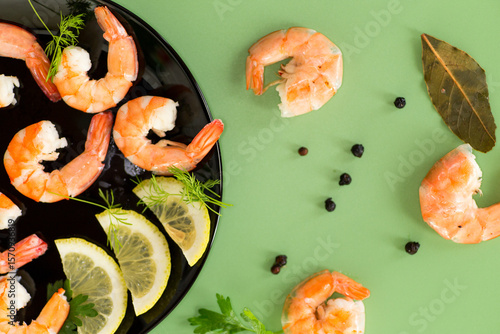 Canvas-taulu Boiled seafood shrimps with lemon isolated on green background