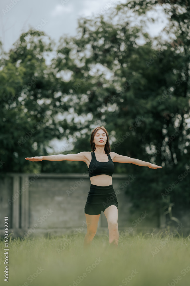 A woman practices yoga outdoors on a grassy field, wearing activewear, stretching gracefully in a calm, natural setting, promoting wellness, flexibility, focus, and a healthy lifestyle. A woman practices yoga outdoors on a grassy field, wearing activewear, stretching gracefully in a calm, natural setting, promoting wellness, flexibility, focus, and a healthy lifestyle.