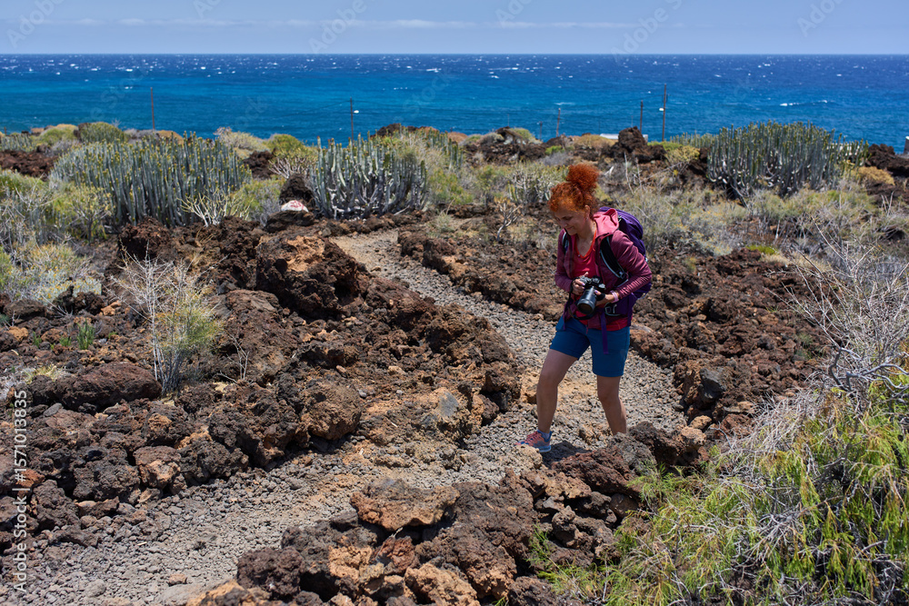 Fototapeta premium Photographer hiking through volcanic terrain
