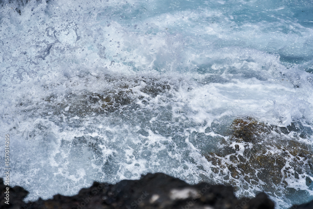 Fototapeta premium Waves hitting volcanic shoreline