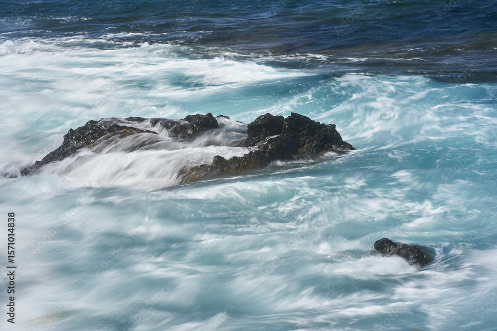 Fototapeta premium Waves hitting volcanic shoreline