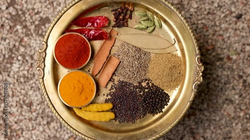 Indian spices ingredient on traditional brass plate 