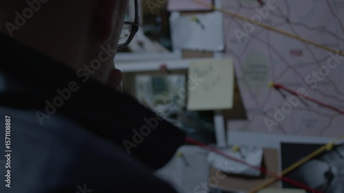Over the shoulder of FBI agent looking at evidence board