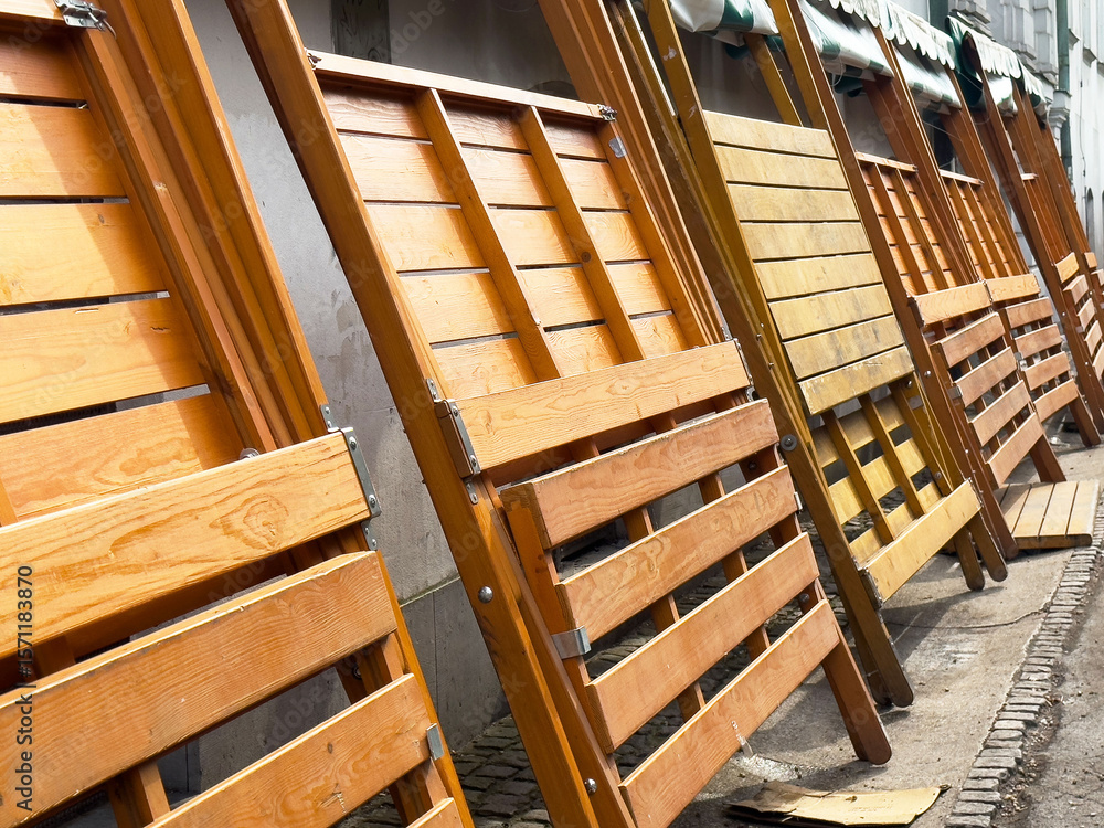Obraz premium Wooden folding tables lined up outdoors near building with green awning