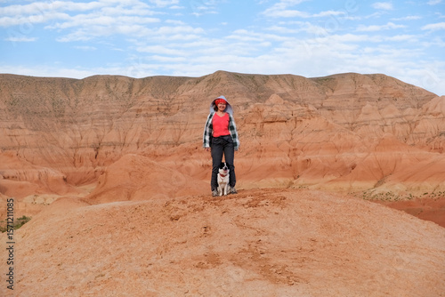 Wallpaper Mural A happy woman smiles, she stands against the backdrop of the beautiful red mountains of Boguta, her dog is next to her, they travel together through the unique nature of Kazakhstan. Torontodigital.ca