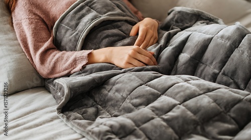 Foto Woman relaxes at home under a soft gray weighted blanket for comfort, relaxation, and a sense of well being