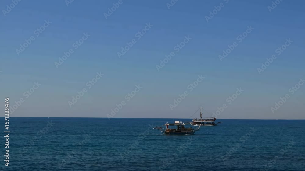 Calm ocean scene with distant sailing boats under clear blue sky in muted blue and pastel tones, video background with copy space on top for travel blogs, meditation content, or vacation branding Calm ocean scene with distant sailing boats under clear blue sky in muted blue and pastel tones, video background with copy space on top for travel blogs, meditation content, or vacation branding