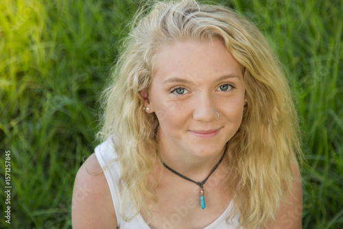 Close up of a blonde teen smiling outside