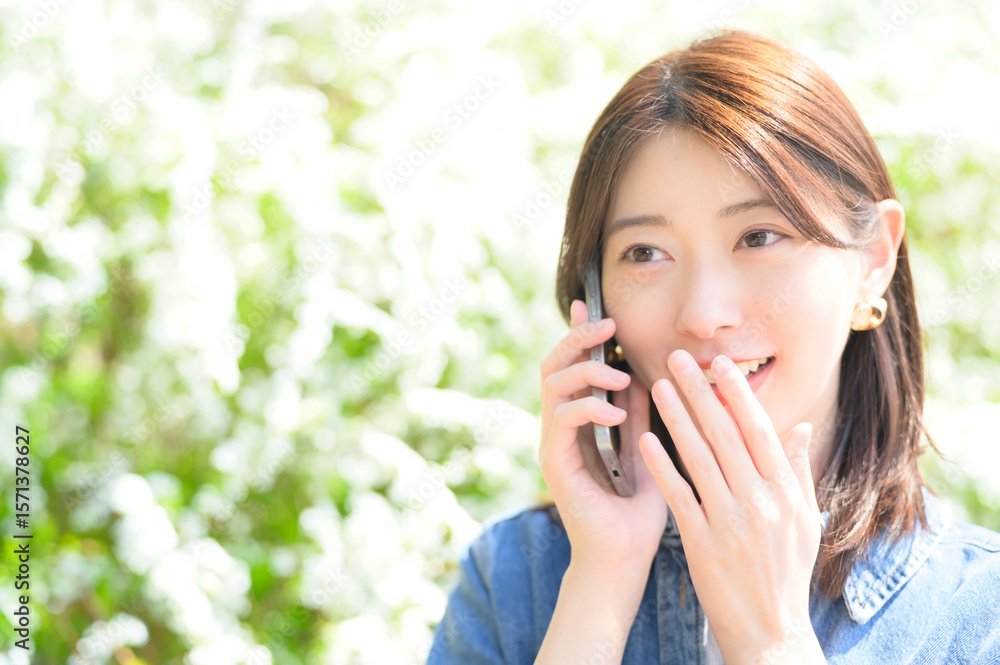 公園で電話をする日本人女性 公園で電話をする日本人女性