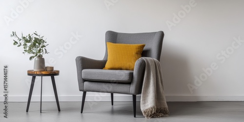 Interior of living room. Gray armchair, green pillow, coffee table and beige wall. Velour Chair against light wall, wooden floor, parquet. Home improvement. Beautiful luxurious modern room settings.